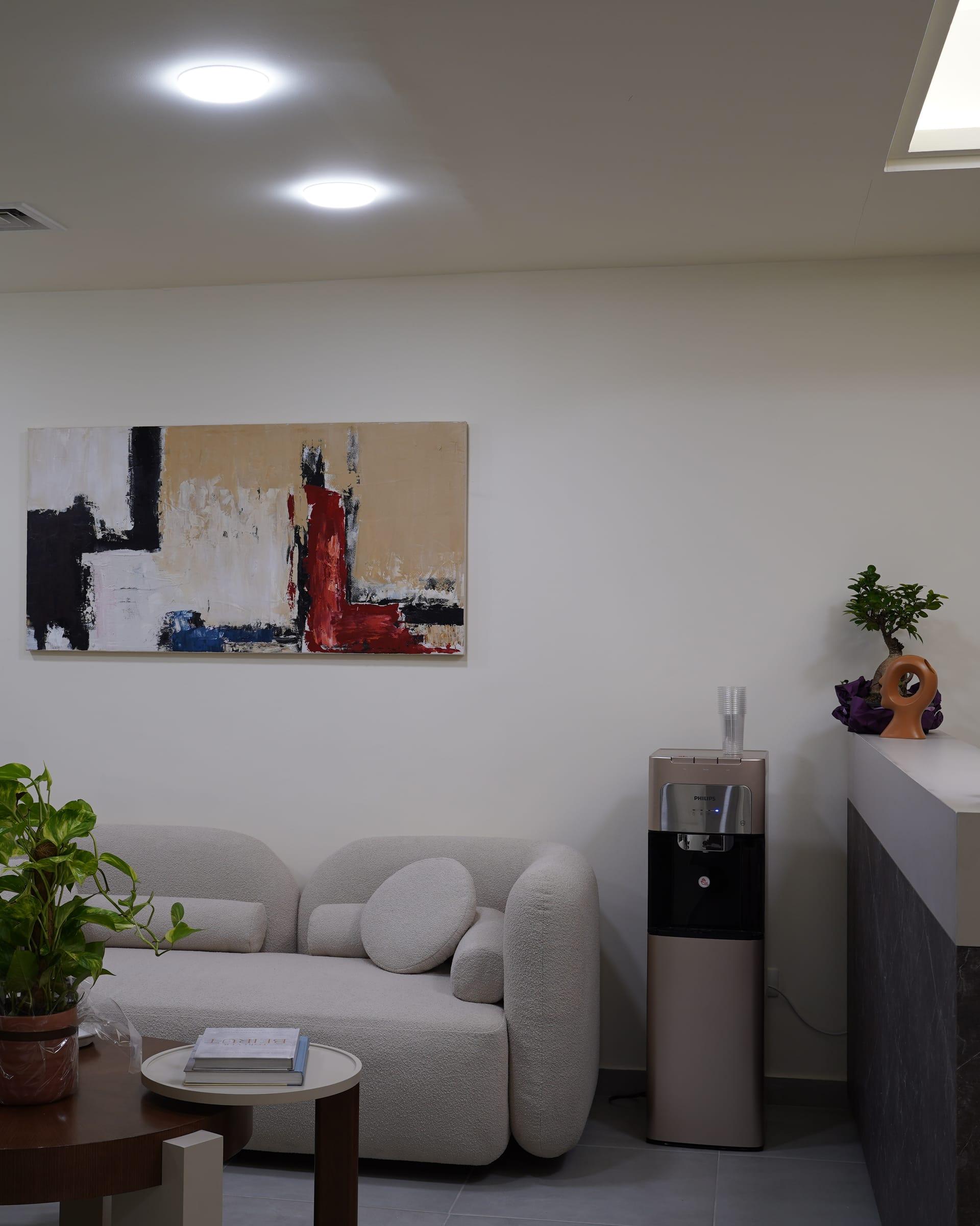 Waiting area with a sofa and abstract artwork at the Le Dermato clinic in Dbayeh